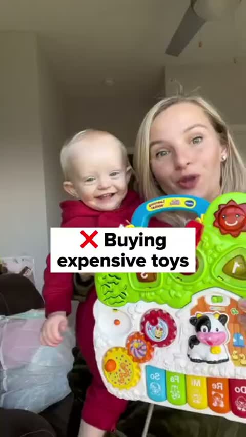 Maddy holding her baby next to a learning toy