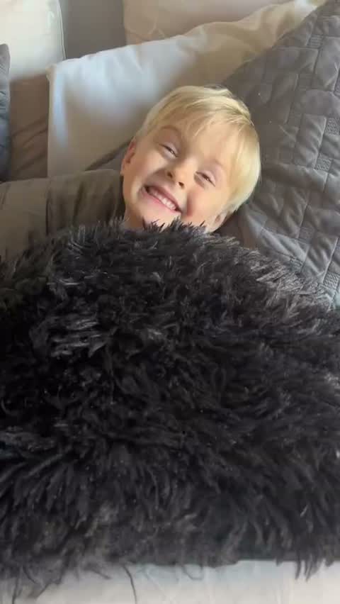 Kid smiling on a bed