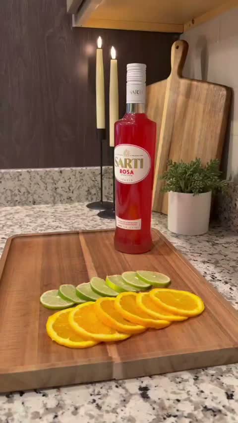 Aperitivo bottle with sliced citrus on a cutting board