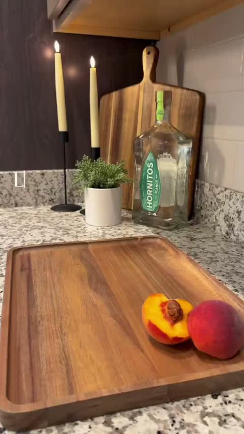Fresh peaches and tequila on a marble counter