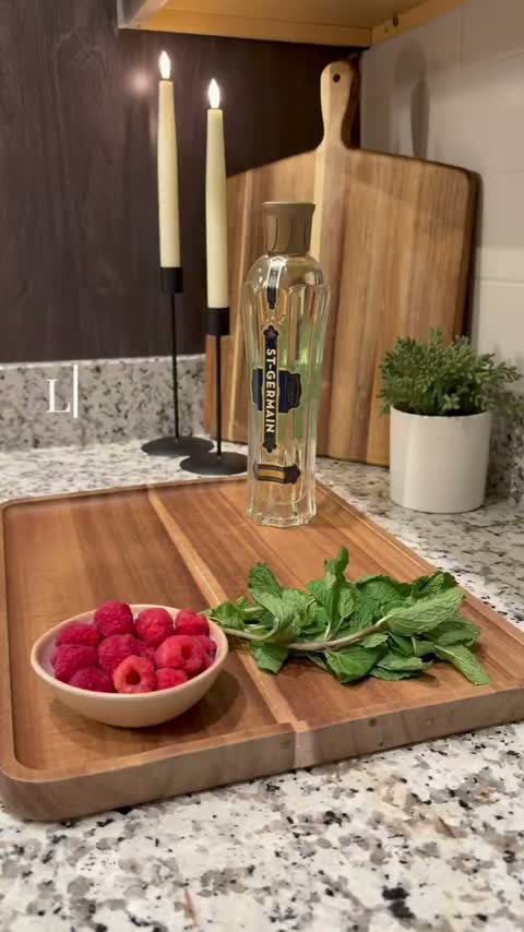 Cocktail setup with raspberries, mint and candles